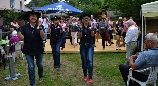 Viele Bewohner und Gäste zog es auf die Bühne, als die Line Dance Gruppe in einem kleinen Workshop einen Westerntanz einübte. (Foto: E.T. Müller)