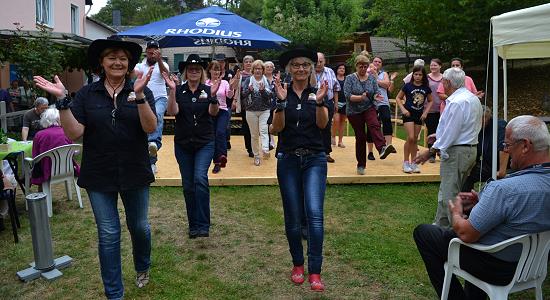 Viele Bewohner und Gäste zog es auf die Bühne, als die Line Dance Gruppe in einem kleinen Workshop einen Westerntanz einübte. (Foto: E.T. Müller)